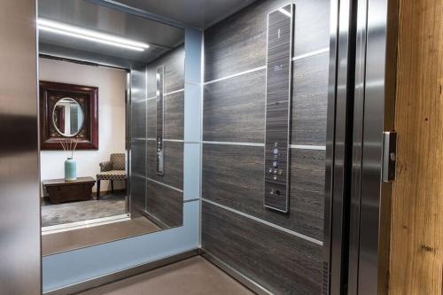 a hallway with a sliding glass door with a mirror at Le Chalet Blanc in Megève