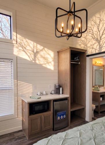 Una cocina con fregadero y lámpara de araña. en TH25 Red Rock Modern Tiny Home - 15 min to Sedona, en Cottonwood