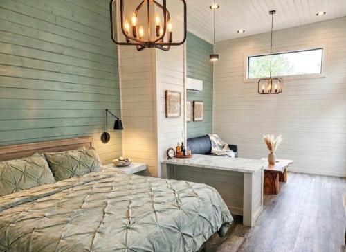 un dormitorio con una cama, un escritorio y una ventana en TH25 Red Rock Modern Tiny Home - 15 min to Sedona, en Cottonwood