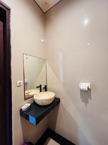 a bathroom with a sink and a mirror on the wall at Guest House Reisya in Nusa Dua