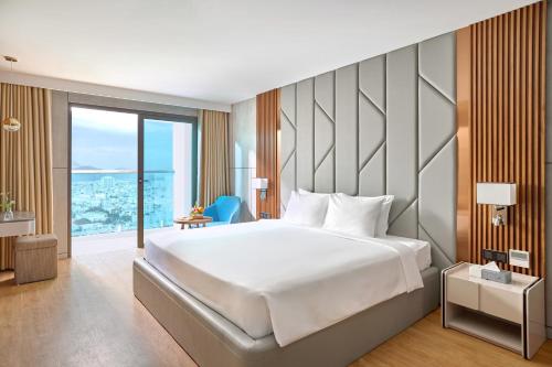 a bedroom with a large bed and a large window at PANAMA Nha Trang Hotel in Nha Trang