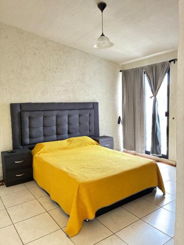 a bedroom with a yellow bed and a window at House check-in anytime after 3 pm in Jurica