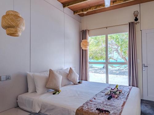 a bedroom with a bed with a large window at Thundi Ocean View in Maalhos