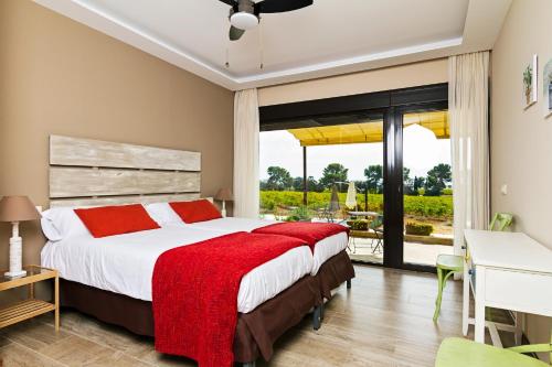a bedroom with a large bed with a red blanket at Casa Rural Monte Higueras in Corral de Almaguer