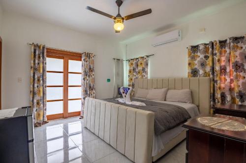 a bedroom with a bed and a ceiling fan at Cozy home in puerto plata in San Felipe de Puerto Plata