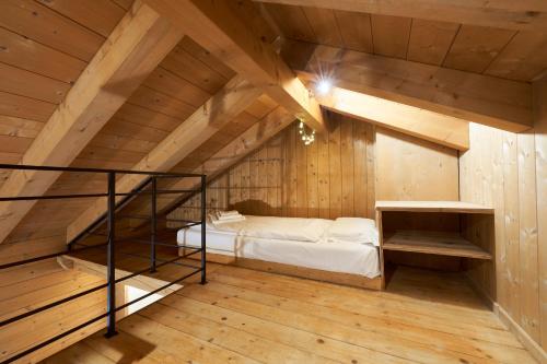 a attic room with a bed and a staircase at Lioda Pera Paradise in Pieve di Cadore