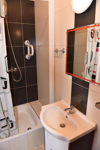 a bathroom with a sink and a shower at Pokoje Gościnne Perłowa in Kołobrzeg