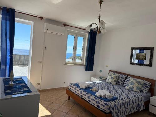 a bedroom with a bed and a large window at Ponzamania Terrazza sul tramonto in Ponza