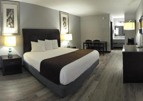 a large bed in a hotel room with two lamps at Western Inn in Forest Park