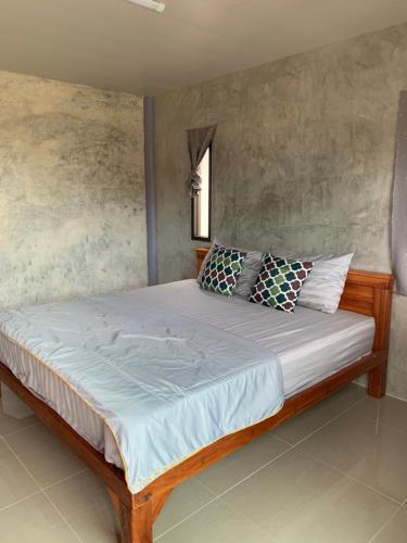 a bed with pillows on it in a room at Poopreaw Koh Larn in Ko Larn