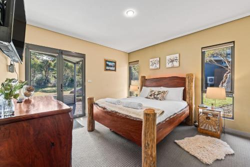 a bedroom with a large wooden bed in a room at Kickenback Lodge - 3BR Lodge l Gym l Indoor Pool l Tennis l WiFi l Air-Con in Crackenback