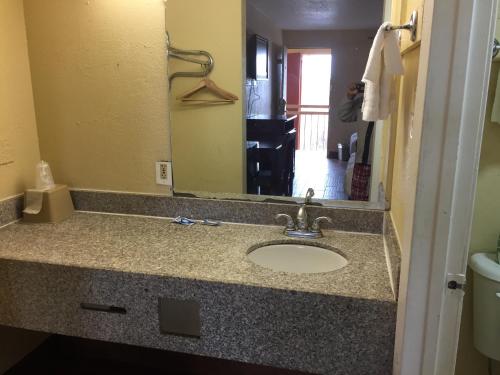 encimera con lavabo y espejo en Diamond Inn Motel, en Jackson