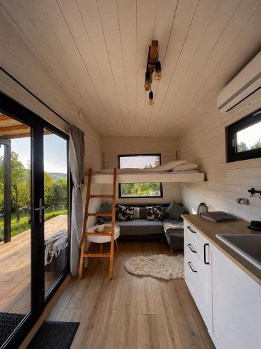 a tiny house with a kitchen and a bunk bed at The Tiny House in Râşnov