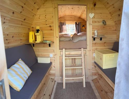 a small cabin with a bed and a ladder in it at Obstgarten im Warnetal- Campingfass Wabe in Gielde
