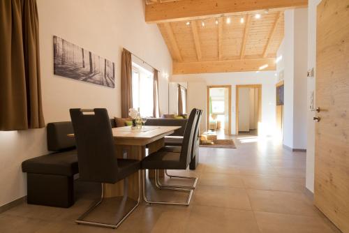 a dining room with a table and black chairs at Alps 3000-2 in Umhausen