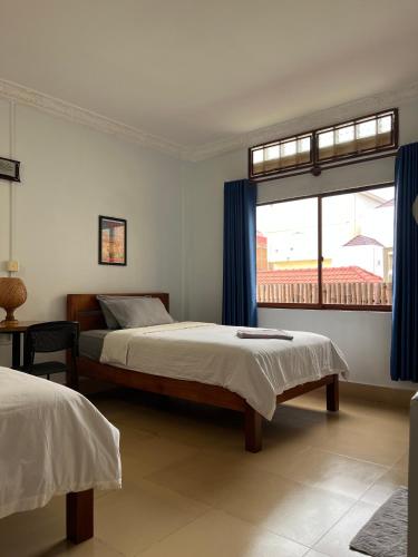 a bedroom with two beds and a window at Sorya Guesthouse & Dolphin Tours in Kratie