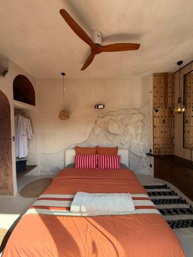 a bedroom with a large bed with a ceiling fan at Casa Amor in Fretin