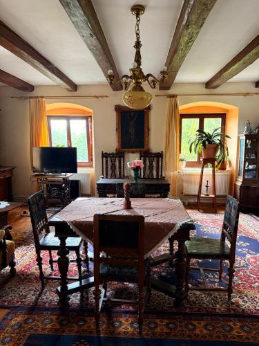a dining room with a table and chairs and a television at Statek Vojtěšín in Vojtěšín