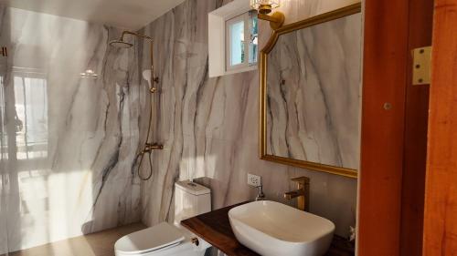 a bathroom with a sink and a toilet and a mirror at Binucot Pearl Boutique Resort in Ferrol