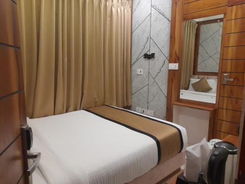 a small bedroom with a bed and a shower at Accom Hotel in Ilām