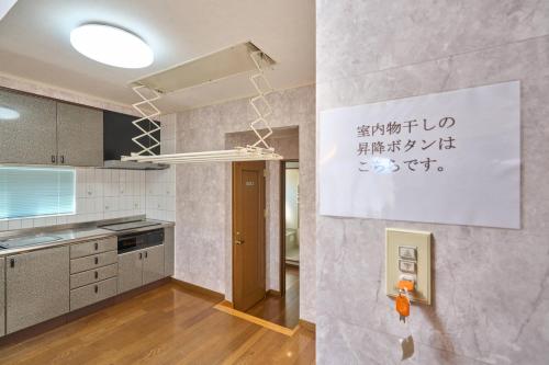 a kitchen with a wall with writing on it at Sapporo Vacation Home B&B in Sapporo
