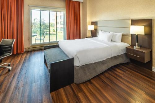 a hotel room with a large bed and a window at Chateau Cartier Hotel & Resort, an Ascend Collection Resort in Gatineau