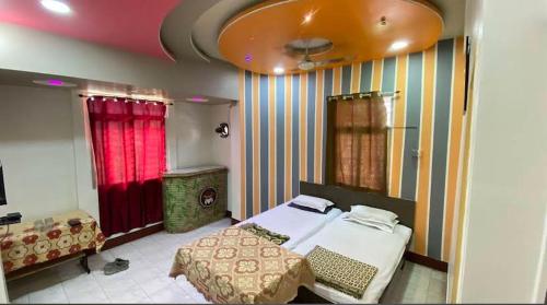 a bedroom with a bed and a red curtain at Muktai Lodge in Solapur