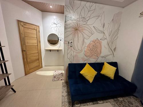 a blue couch with two yellow pillows in a room at Villas Transient Inn in San Juan