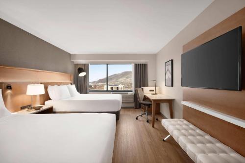a hotel room with two beds and a flat screen tv at Radisson Hotel Salt Lake City Downtown in Salt Lake City