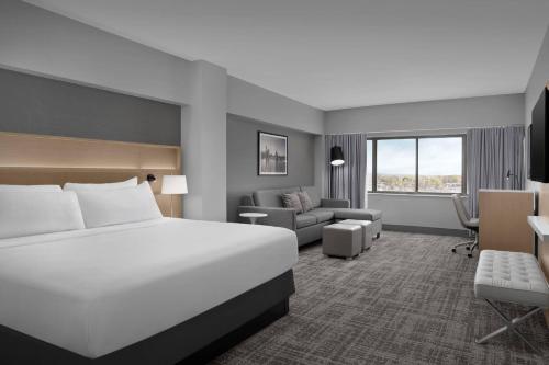 a hotel room with a large bed and a couch at Radisson Hotel Cedar Rapids in Cedar Rapids