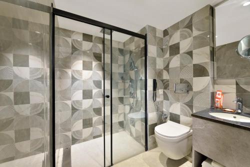 a bathroom with a shower and a toilet and a sink at Ginger Hyderabad Genome Valley in Turkapally