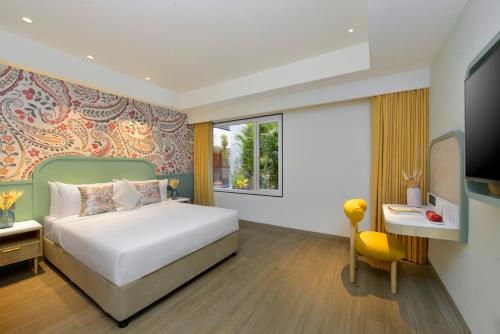 a bedroom with a bed and a desk and a television at Ginger Hyderabad Genome Valley in Turkapally