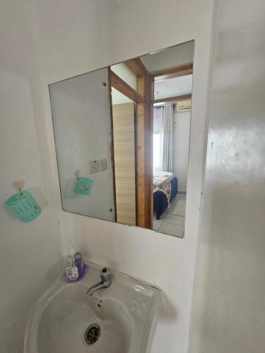a bathroom with a sink and a mirror at Cindy's Ample home in Mombasa