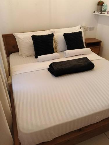 a bed with a black bag sitting on top of it at Cindy's Ample home in Mombasa