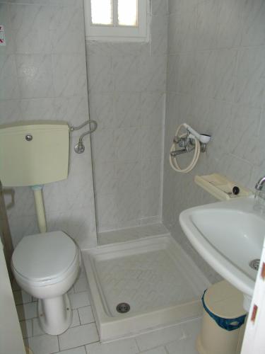 a white bathroom with a toilet and a sink at Irene Studios in Kefalos