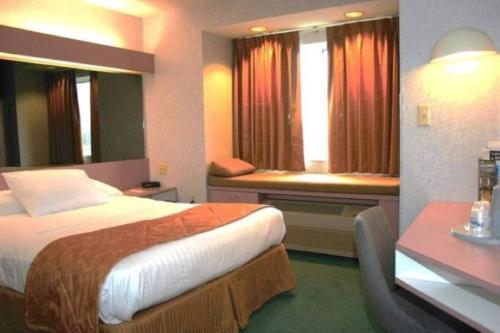 a hotel room with a bed and a window at CenterWay Hotel Buffalo North Near University in Tonawanda
