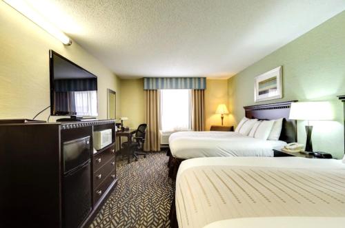 a hotel room with two beds and a flat screen tv at Fireside Inn and Suites in Devils Lake