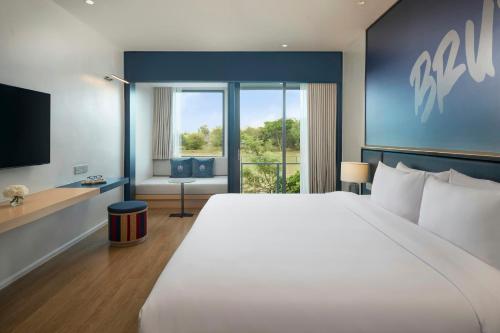a hotel room with a large bed and a television at Amari Buriram United in Buriram
