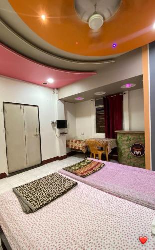 a room with two large beds in a room at MUKTAI LODGE in Solapur