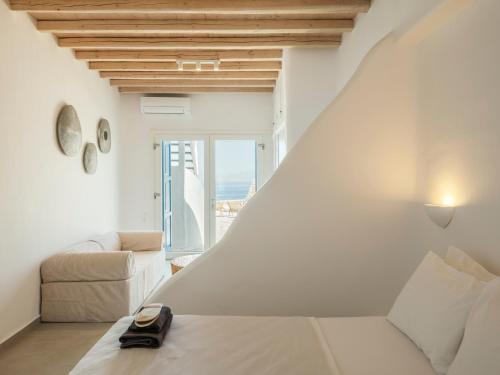 a white room with a bed and a couch at Aqua Lumen Private Pool Villa, Mykonos in Agios Ioannis Mykonos