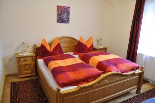 ロイタッシュにあるStöffelhofのベッドルーム1室(カラフルな枕付きのベッド2台付)