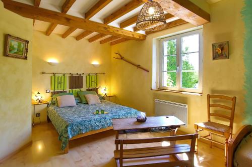 a bedroom with a bed and a table and a chair at Chambres D'hôtes Dans Le Cotentin in Teurthéville-Bocage