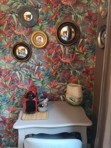 a table with three mirrors on a colorful wall at Chez Mikki in Cassaniouze