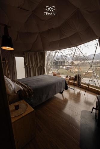 a bedroom in a tent with a bed and a window at Tevani Glamping in Gyulagarak