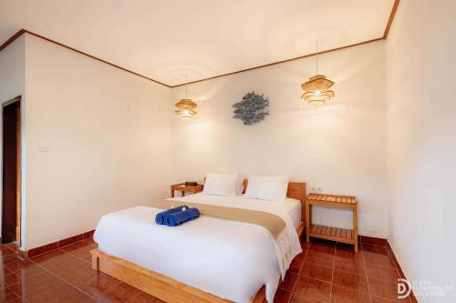 a bedroom with a bed with a blue bag on it at Paradise Palm Beach Bungalows and Dive Center in Tulamben