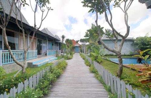 a wooden path leading to a house with trees at Casa Batu Belig in Seminyak