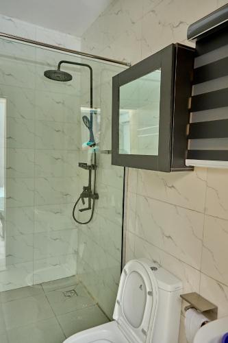 a bathroom with a shower with a toilet and a sink at Lekki Abijo Apartment in Lekki