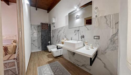 a white bathroom with a sink and a toilet at L'ALGA in Càbras