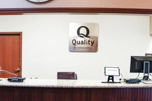 a sign on a wall above a counter with a computer at Quality Inn Dover in Dover