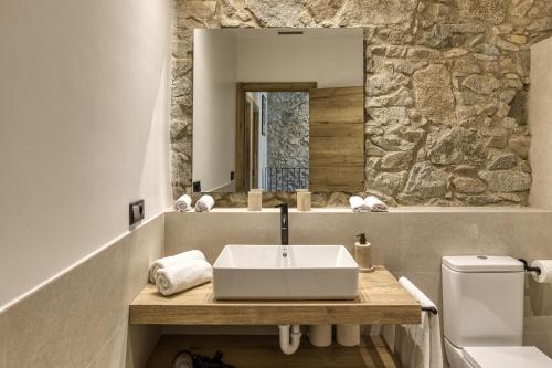 a bathroom with a sink and a stone wall at El Corral in Agullana
